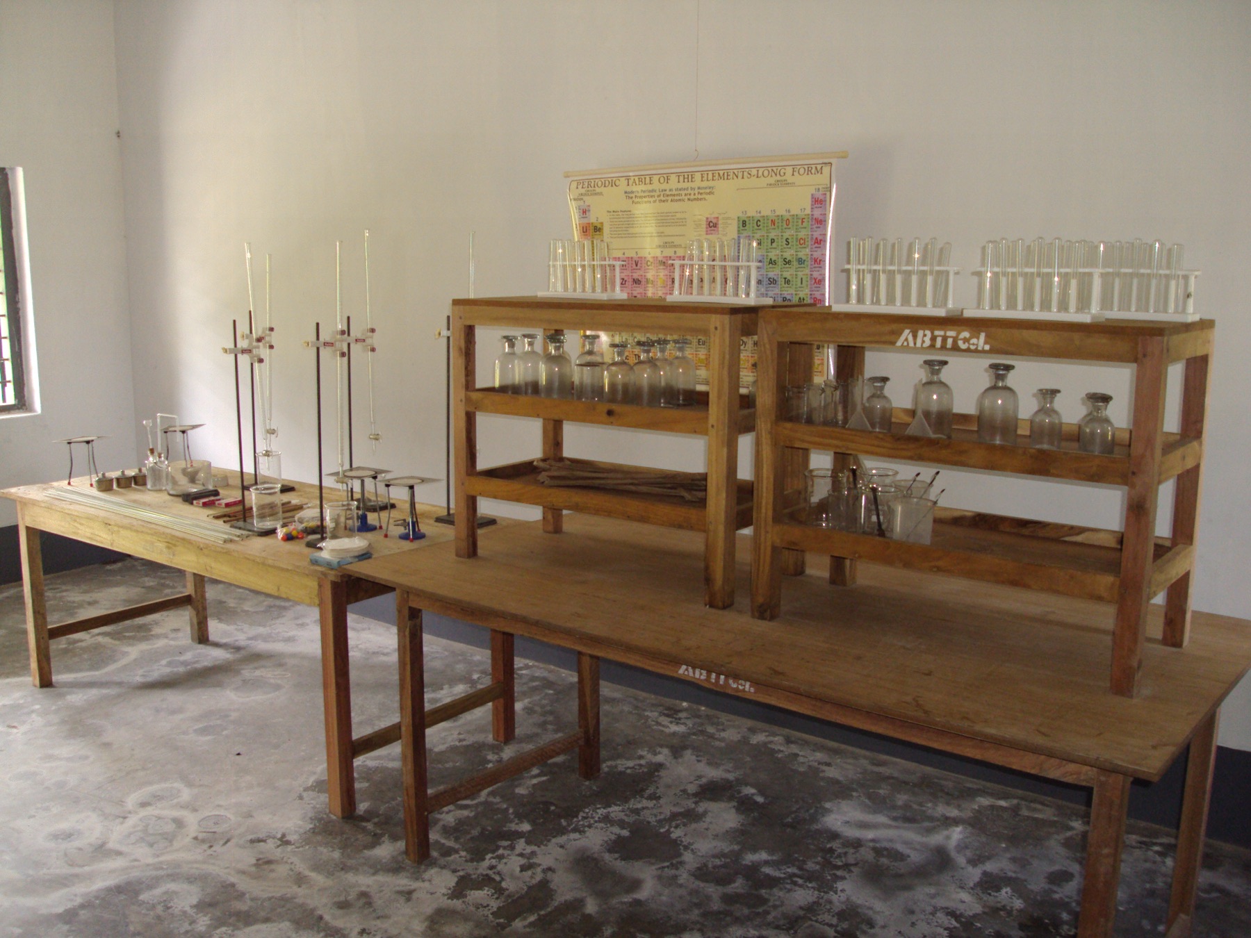 Chemistry lab with periodic table chart, reagent bottles and test tubes